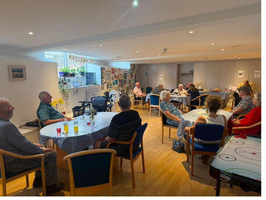 The main room at the day centre, with tables laid up and a welcome banner in the window