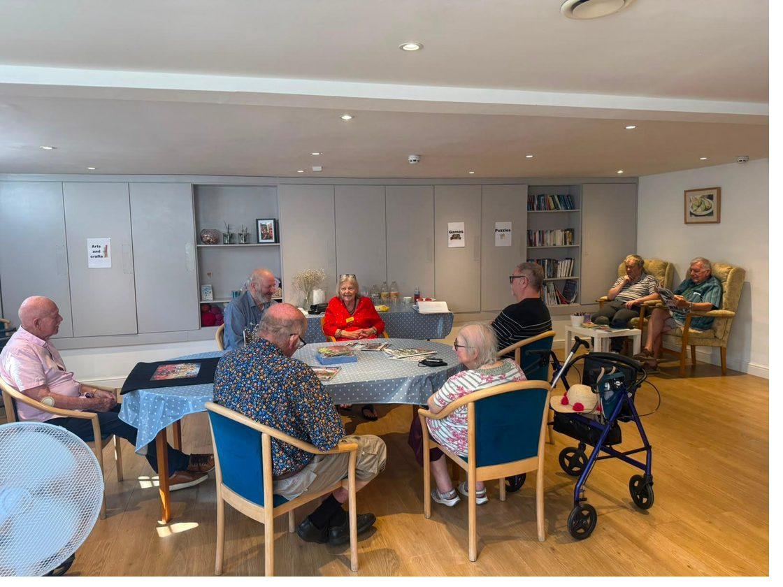 Guests sitting and chatting together around a table in the main room