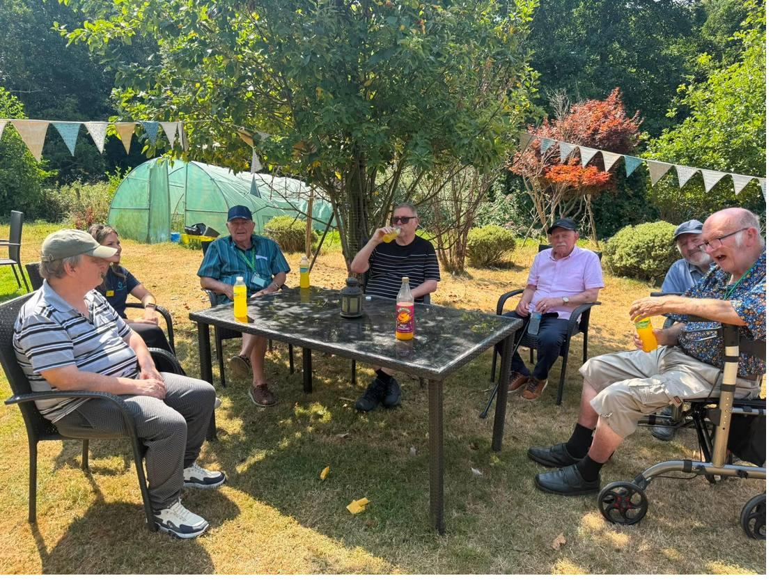 The group having cold drinks in the shade of a tree in the garden