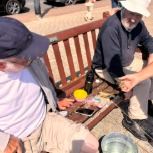 Two guests sitting on a quayside bench in the sunshine